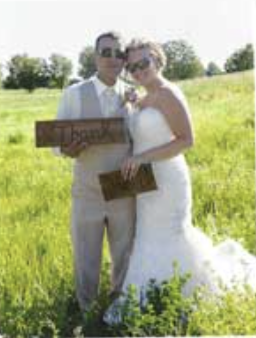 Jodie & Nick pose in a sunny field on their wedding day