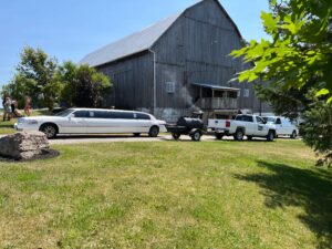 Wedding party arrives at barn in stretch limo