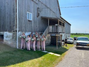 Wedding party photographed in shadow of the barn in Beaverton