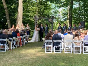 Wedding ceremony in the shade of mature trees at Quayle's Brewery