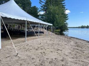 A picturesque setting for a wedding celebration - calm water, large trees and sandy shores