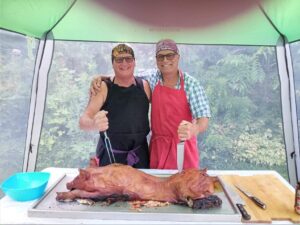 Sue Garagan and Friend pose with DIY roast pig