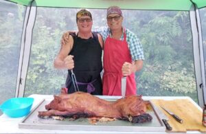 Sue Garagan and Friend pose with DIY roast pig