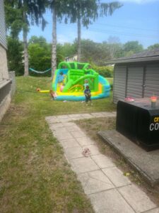 Kids enjoy the bouncy castle in a nearby yard
