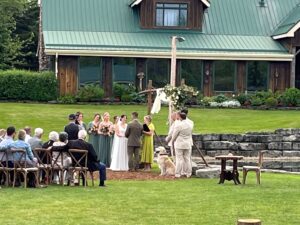 Vows are exchanged by the water with man's best friend serving as an attendant