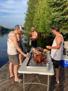 Josh and his friends enjoy a freshly roasted pig at their DIY bachelor party at this Haliburton cottage - Shaws DIY Pig Roast